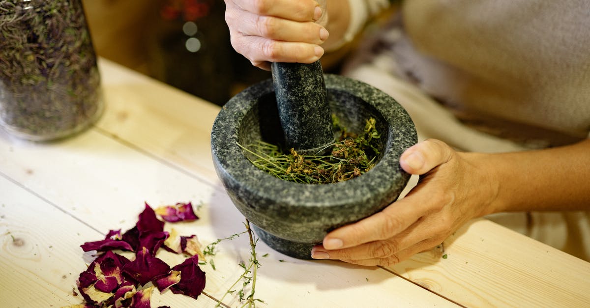 Are there substantial benefits to grinding your own flour? - Close-up of a Person Grinding Spices in a Mortar