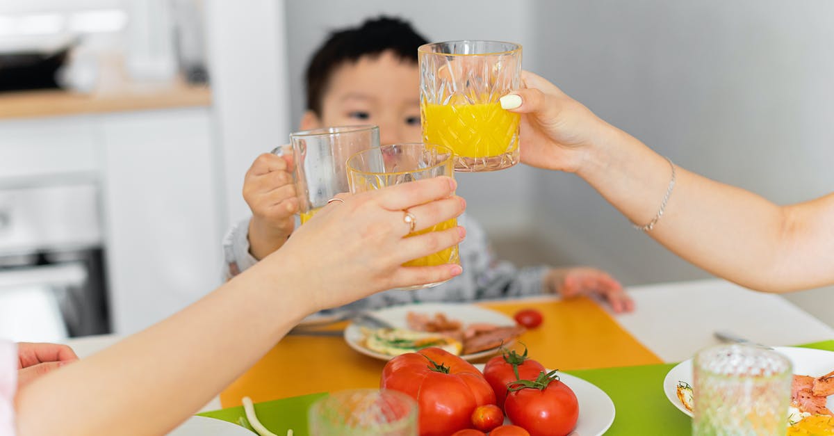 Asian toasting seeds - Two Women and Boy Toasting with Glasses of Juice During Dinner