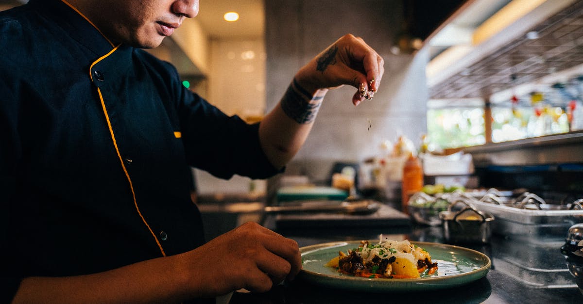 Asian toasting seeds - A Chef Sprinkling Sesame Seeds on a Salad Dish