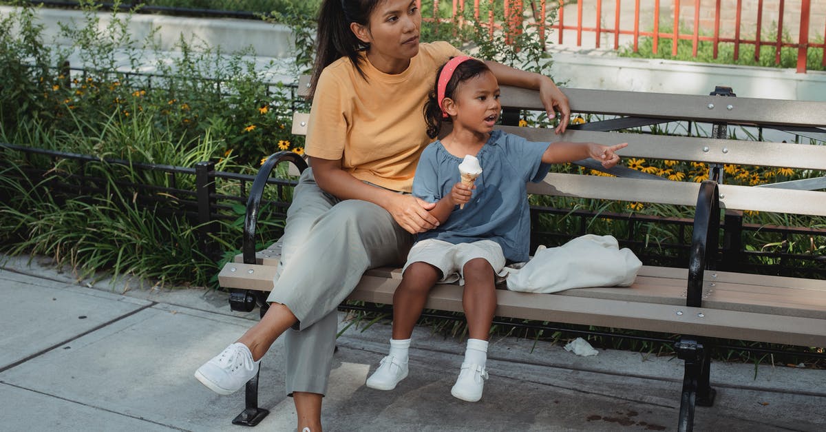 At what point (after clams die) are they ok to eat - Asian mother and kid sitting on bench on street in sunny day