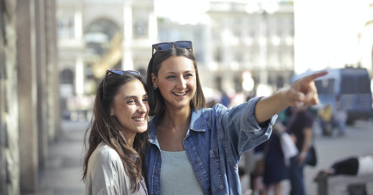 At what point should carrots be thrown away? - Happy young female friends laughing and looking away while woman in denim shirt pointing to funny place