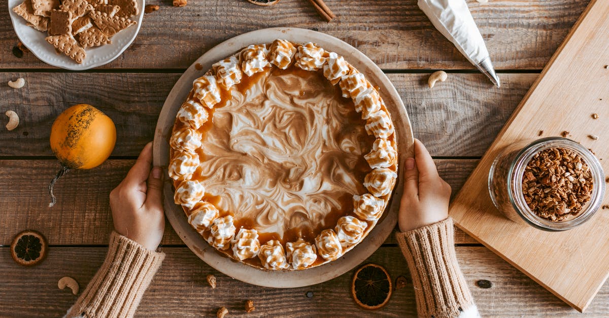 At what pressure is whipped cream stored in a can? - Top view crop anonymous female in sweater serving freshly baked yummy pie with whipped cream on wooden table