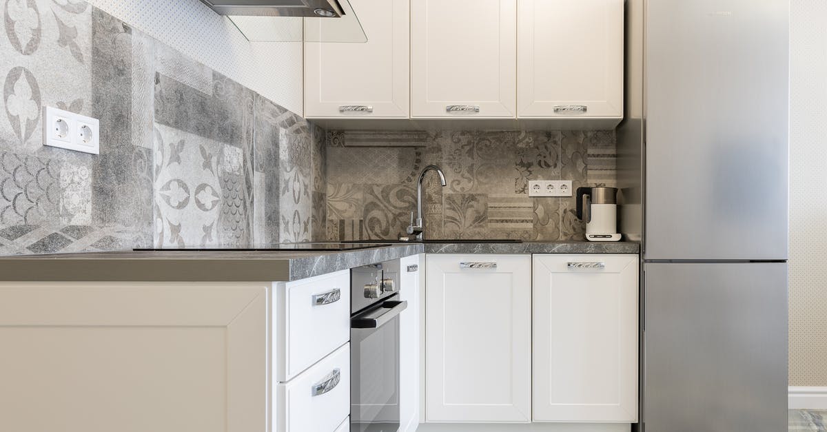 Bag-cooked omelettes turning gray when stored in the fridge - Modern kitchen interior with white cabinets and fridge against electric kettle and ornamental wall in light house