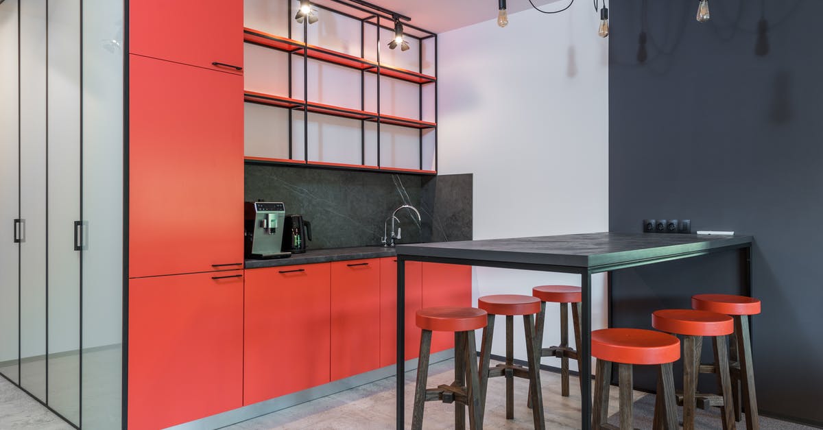 Bag-cooked omelettes turning gray when stored in the fridge - Modern kitchen interior with rows of stools under chandelier with light bulbs against refrigerator and shelves in house