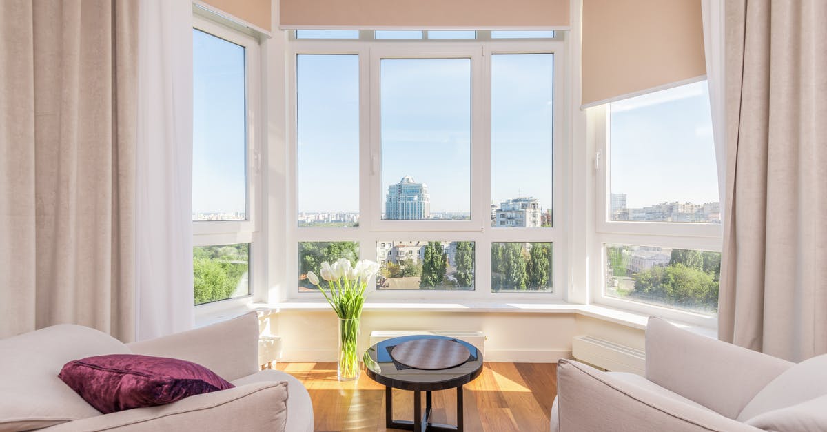 Bagels: Flat, no rise, gummy inside. Over kneading? - Interior of modern penthouse with comfortable white armchairs and round side table placed near windows overlooking city in sunny day