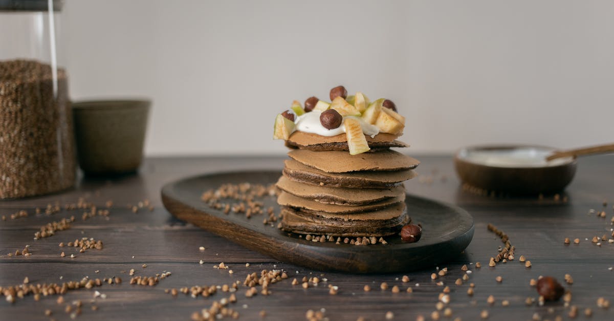 Baked Apple Fritter - Buckwheat grains scattered near plate with yummy pancakes