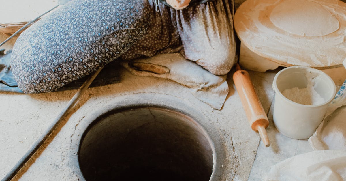 baking bread with all-purpose flour - Person in Black and White Pants Sitting on Brown Concrete Round Pot