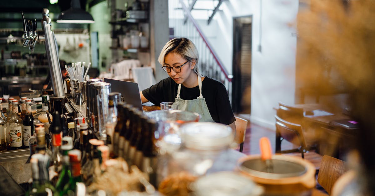 Baking concentrate using Hard Alcohol ex Jack Daniels - Young concentrated Asian female bartender working at counter