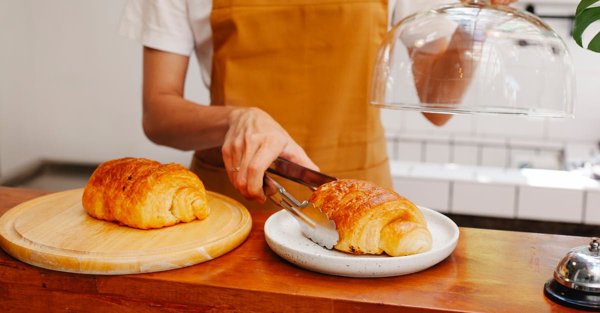 Baking (pizza) stone and effects on puff pastry - Crop baker putting appetizing puff on plate in cafeteria