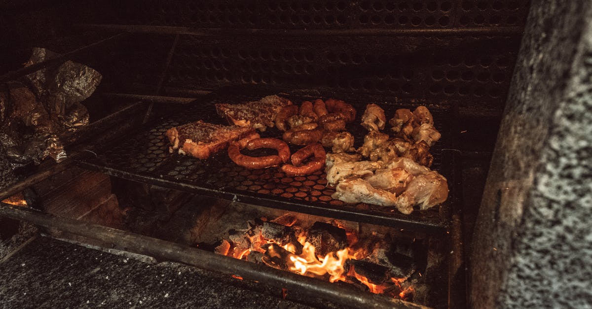 Barbecue on wood fire - Grilled Meat on Black Charcoal Grill at Nighttime