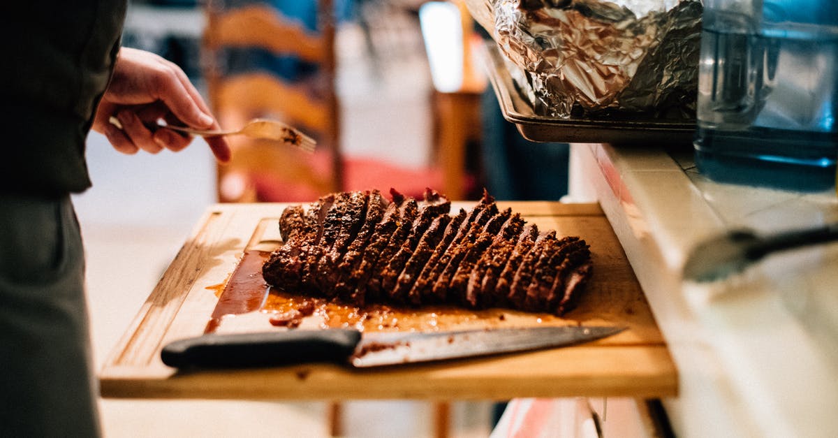 BBQ Beef Brisket on a Propane Grill? - Person Holding Knife Slicing Meat