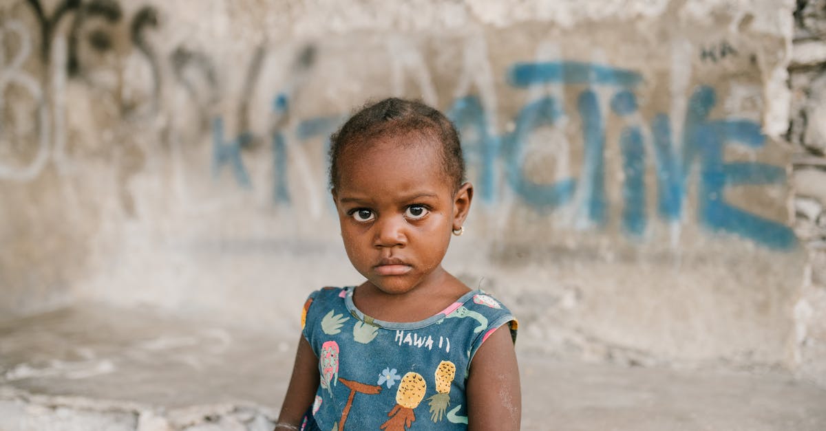 BBQ Rib problem, need suggestions - Frowning African American girl near weathered concrete building with vandal graffiti and broken wall in poor district