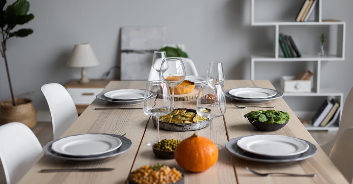 Bean selection for a chili recipe - From above of wooden table served with various vegetarian dishes and empty glasses for guests