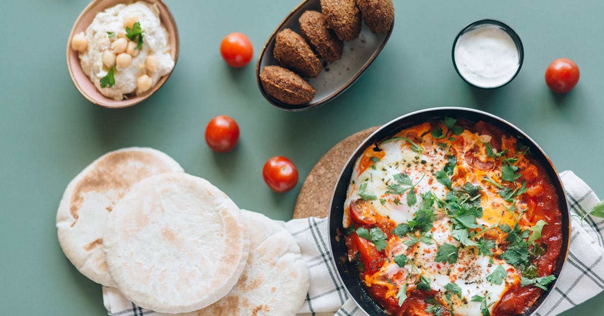 Beaten and poached eggs - Shakshouka, Falafel, Hummus and Pita Breads on the Table