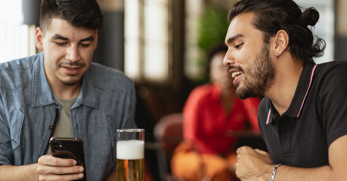 Beer Battered Onion Rings -- what makes them look shiny? - Man in Black T-Shirt Looking at the Phone of Man in Blue Shirt