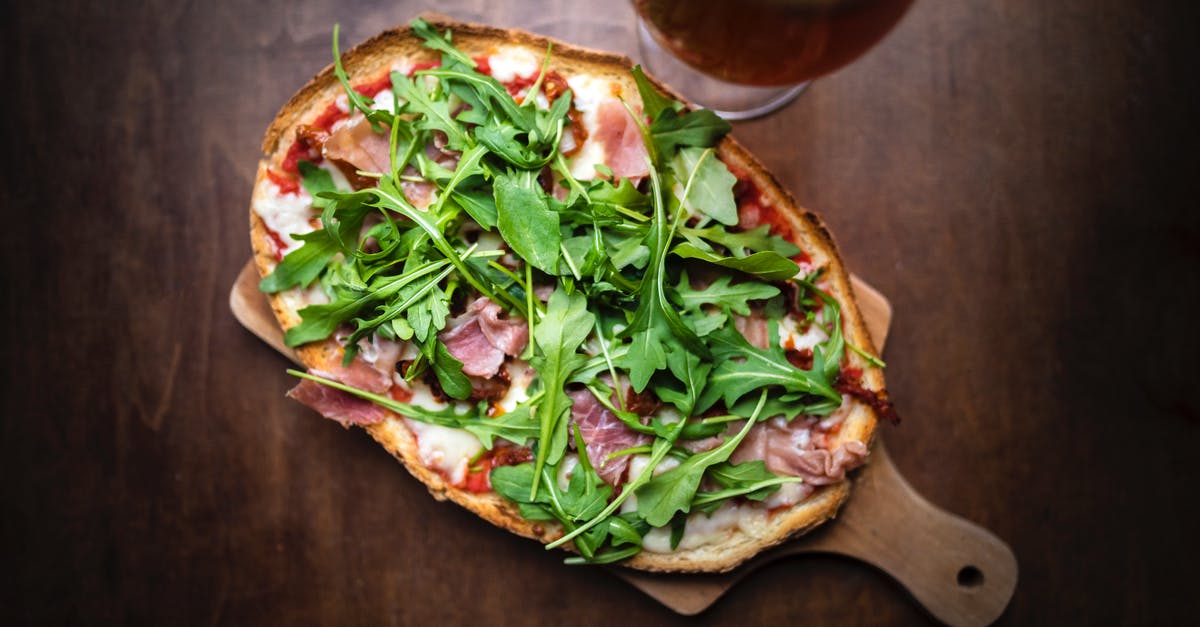 Beer in Sourdough Starter - From above of tasty toast with cured meat slices and melted cheese with fresh herb leaves on brown background