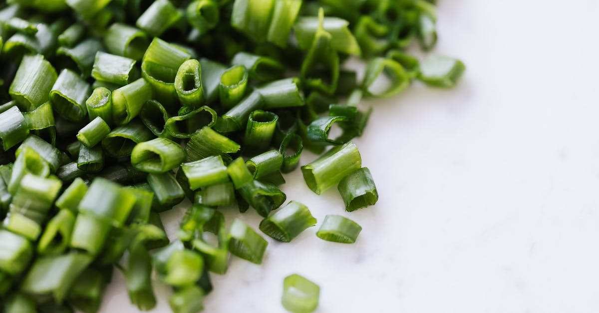 Best way to chop an onion? [duplicate] - From above of fresh spring chopped green onion scattered on white marble table