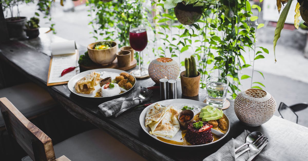 Best way to cook rice to serve cold later? - High angle of plates with assorted healthy dishes served on wooden table with cutlery and drinks in stylish tropical cafe