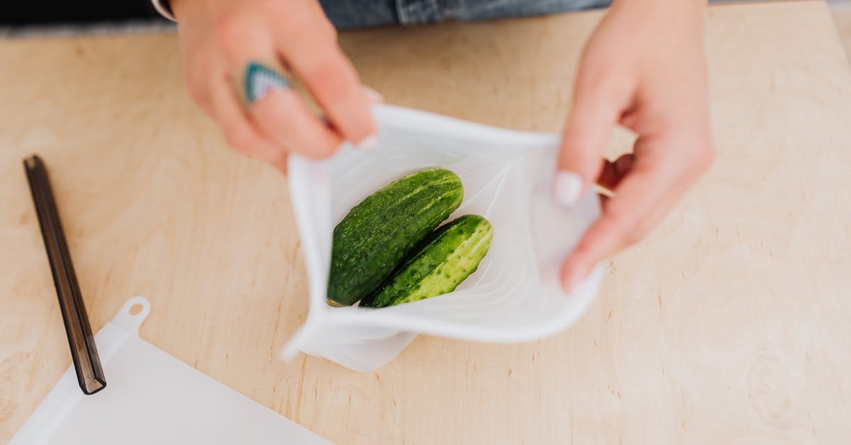 Bitter Cucumbers - Hands Holding Bag with Cucumbers