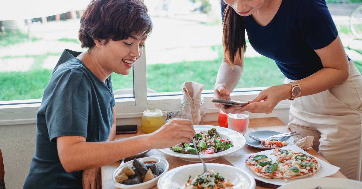 Bitter tasting salad - Asian woman taking photo of dish