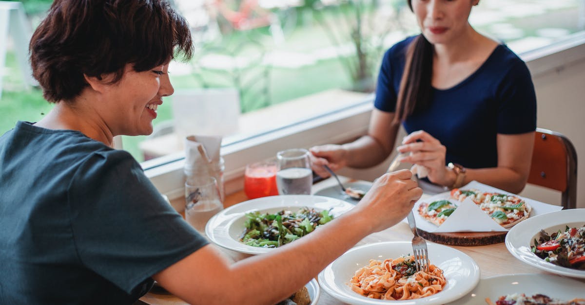 Bitter tasting salad - Asian women having lunch in restaurant