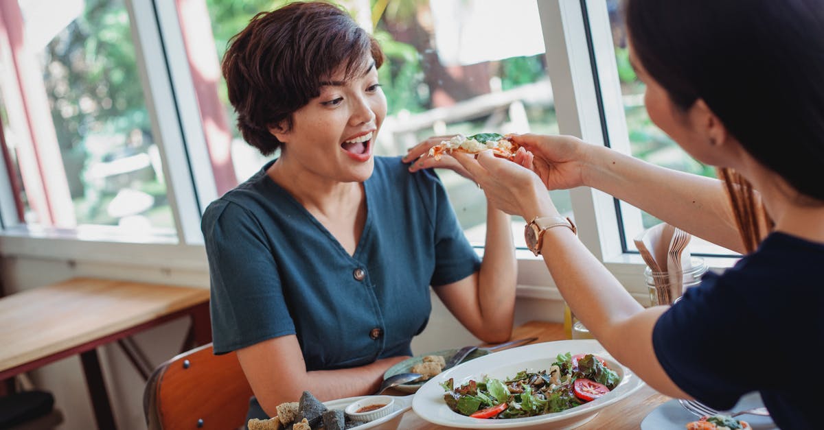 Bitter tasting salad - Crop woman feeding pizza to friend