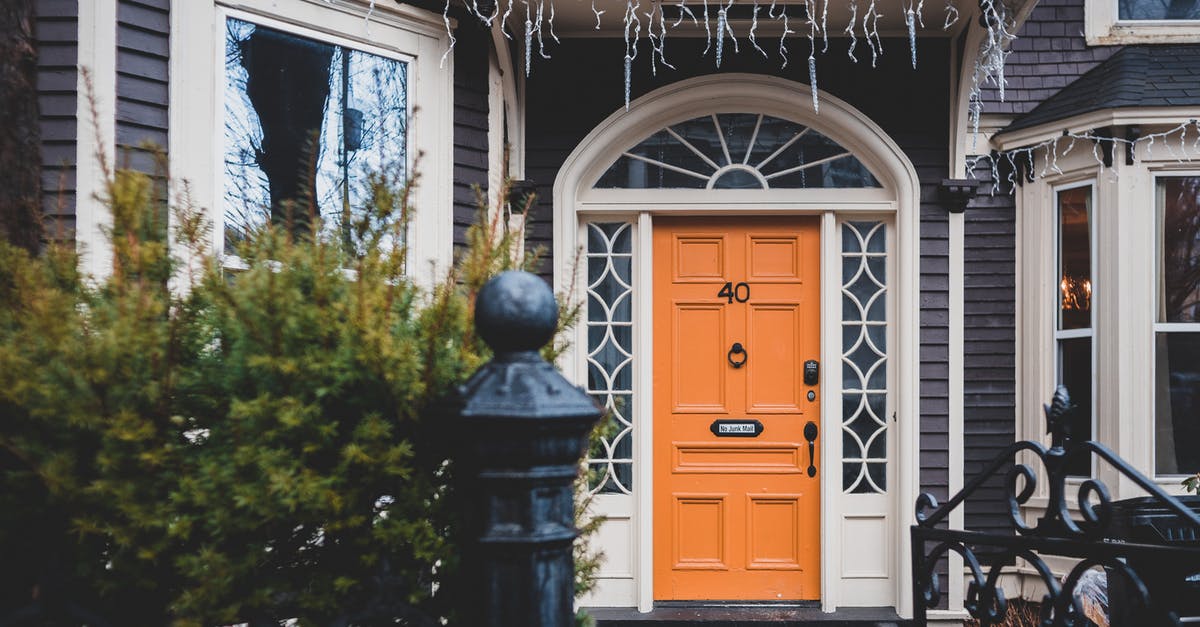 Black flakes from new cast iron pan - Exterior of contemporary wooden orange door and black cast iron gates to house