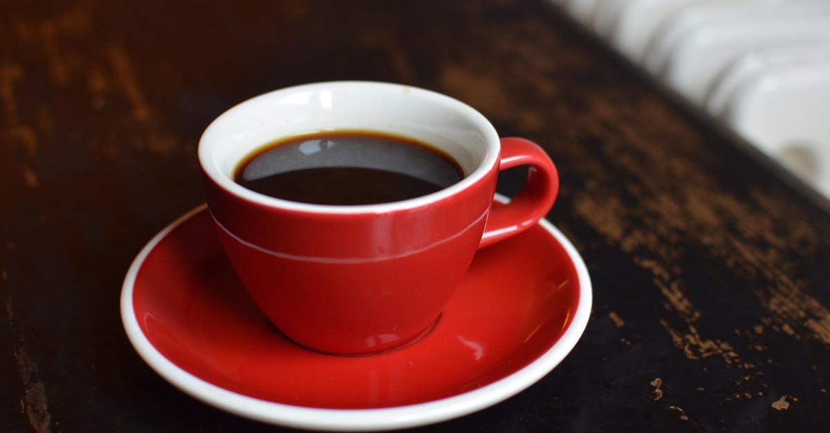 Black spots in porcelain coffee mug - Coffee in cup on table near radiator