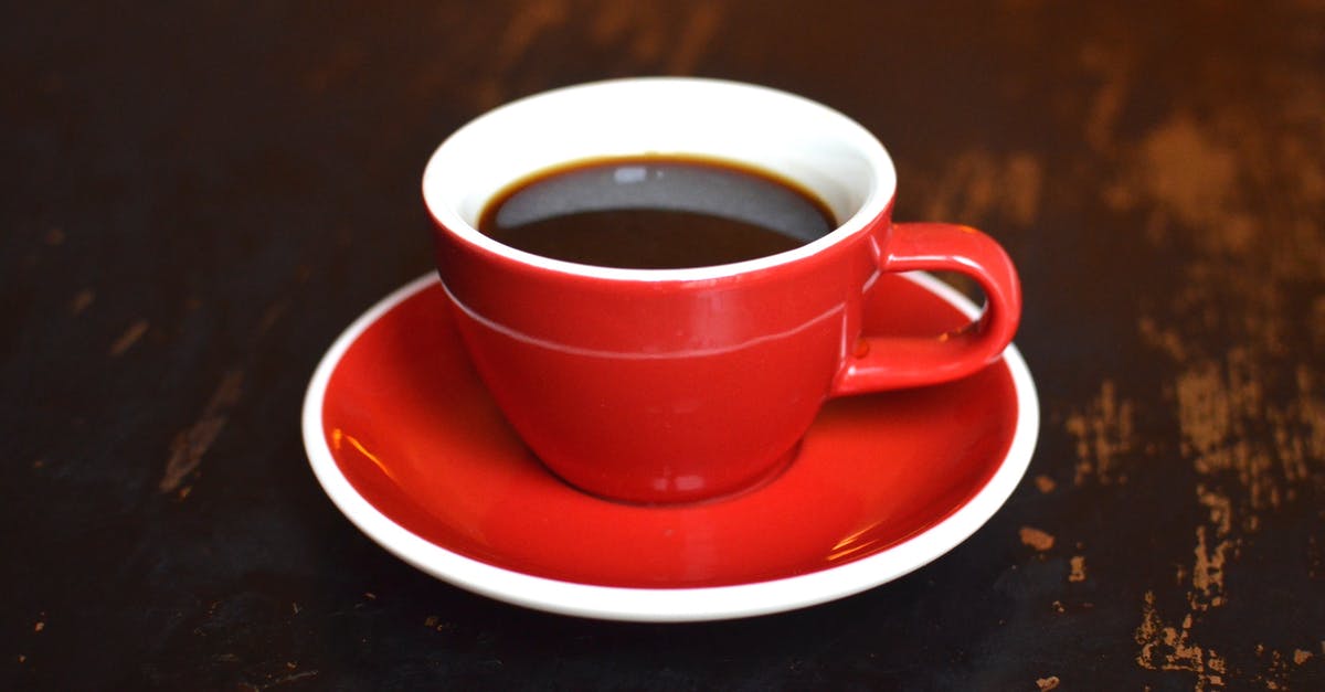 Black spots in porcelain coffee mug - Cup of hot coffee on ceramic saucer