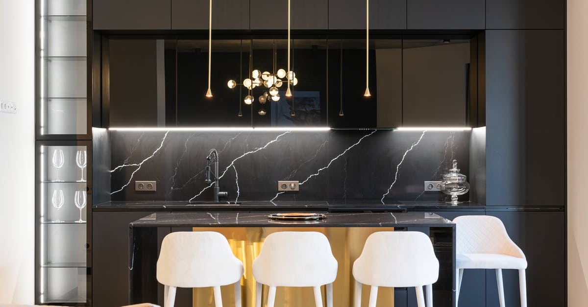 Black spots in the kitchen sink - Kitchen interior with counter near chairs and cabinets