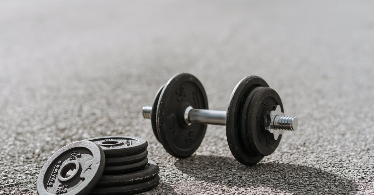 Black spotting/dust in stainless steel utensils.Is this mildew? - Dumbbell near pile of plates on pavement in sunlight