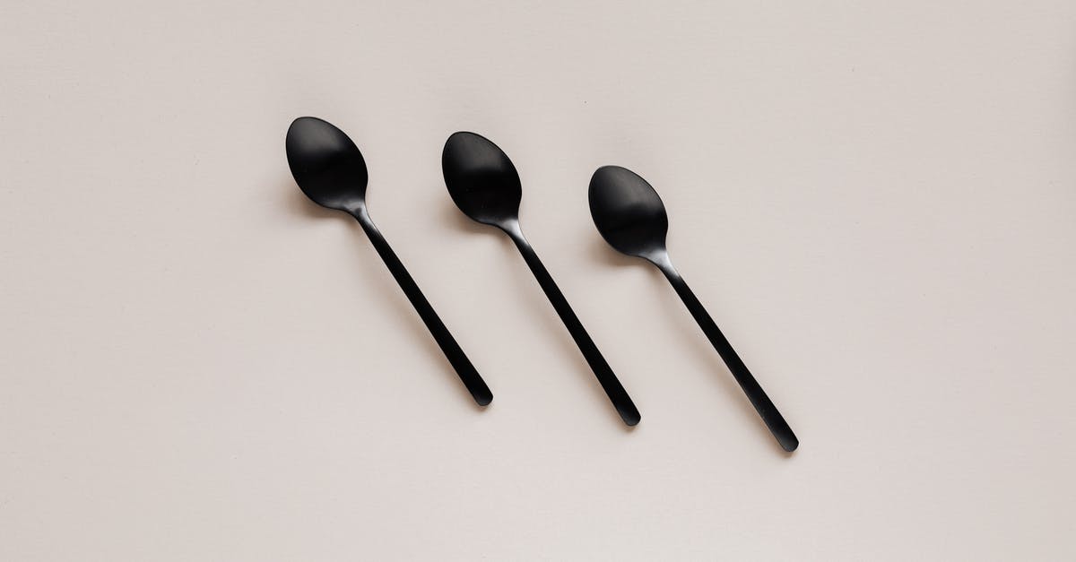 Black/purple ingredient in stir fry? - Set of shiny black spoons on gray table