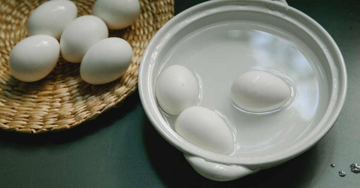Boil an egg in the microwave - Boiled white chicken eggs in saucepan and wicker plate