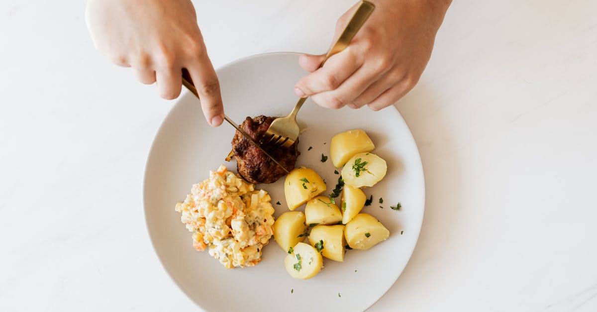 Boiled beef bones and ended up with green marrow...is this normal? - Crop man cutting cutlet on plate with salad and potatoes Boiled beef bones and ended up with green marrow...is this normal? - Crop man cutting cutlet on plate with salad and potatoes