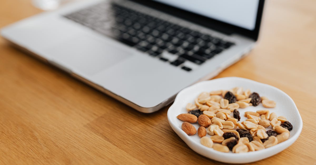 Boiling peeled peanuts - Macbook Pro on Brown Wooden Table