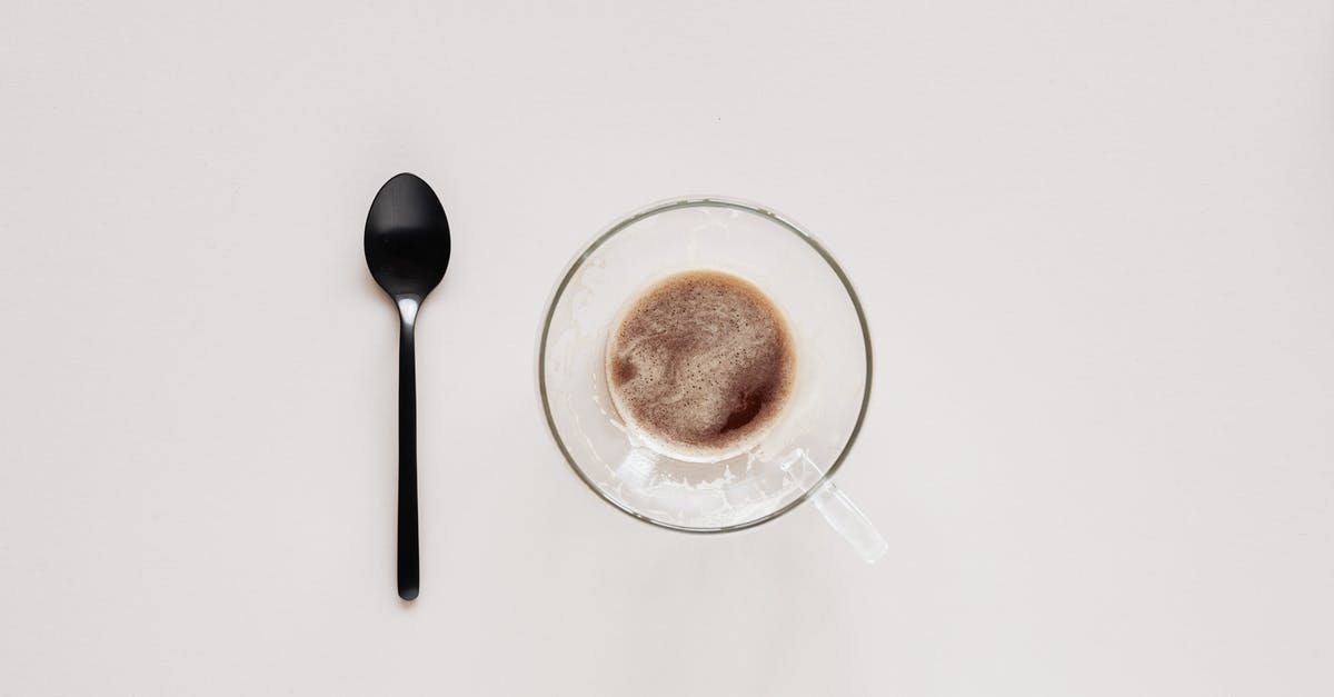 Bold Setting on Coffee Maker - Cup of coffee and teaspoon on beige background