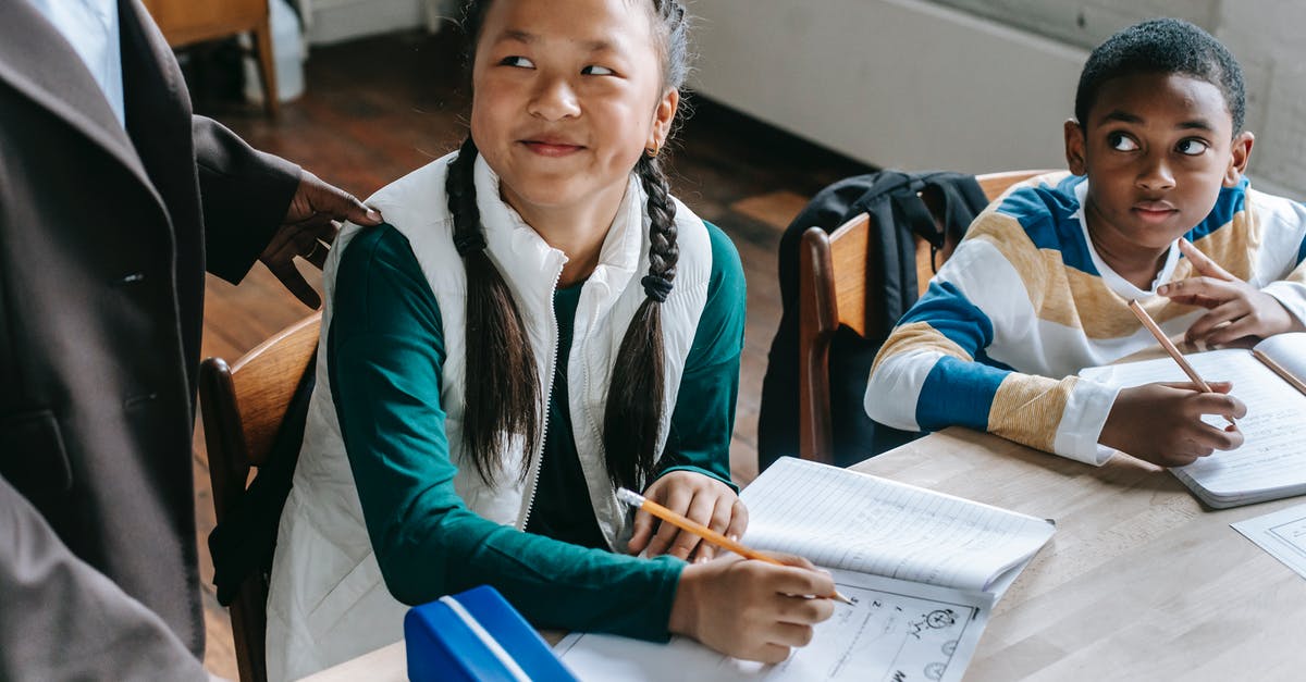 Bone broth question - Crop black teacher talking with smart multiethnic boy and girl siting at desk with notepads