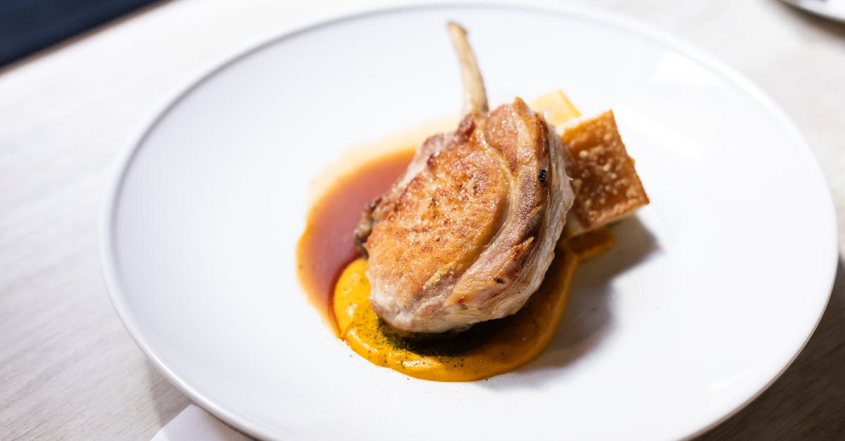 Boneless Frozen Lamb Roast [closed] - From above of appetizing roasted lamb shank garnished with sauce and served on white ceramic plate in restaurant