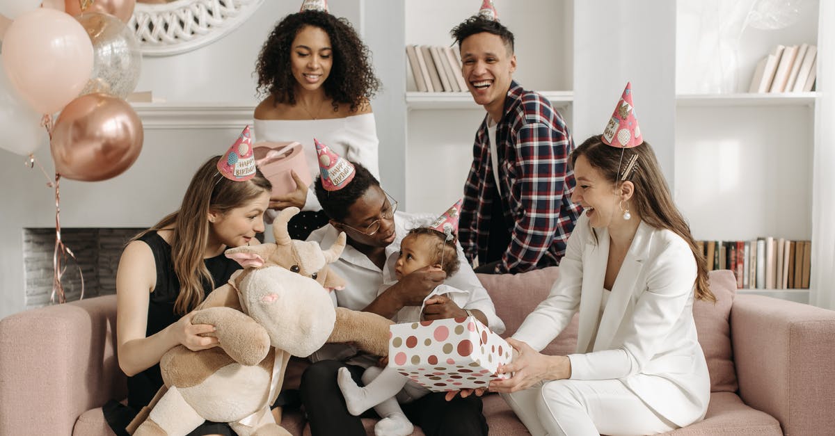 Boxed pancake mix - Allpurpose or Cake Flour? - Baby Girl Sitting on the Man's Knees While Woman in White Suit Sitting on Couch and Holding Polka Dotted Gift Box