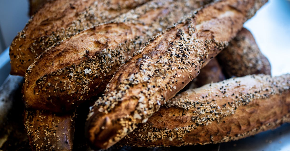 Bread crust separated from interior - Closeup of delicious crunchy baguettes placed on metal counter in kitchen of bake house