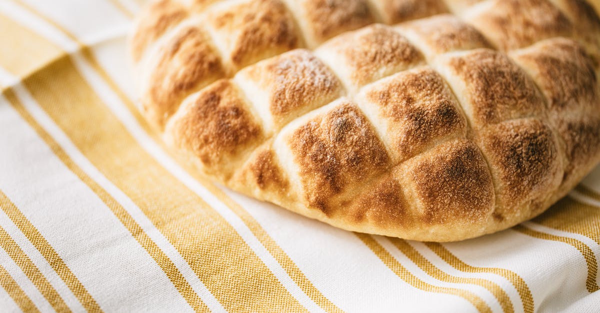 Bread crust separated from interior - Fresh baked bread on striped tablecloth