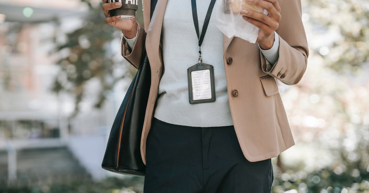 Bread going stale in enamel breadbasket - Crop anonymous ethnic female entrepreneur with takeaway hot drink and bread walking to work