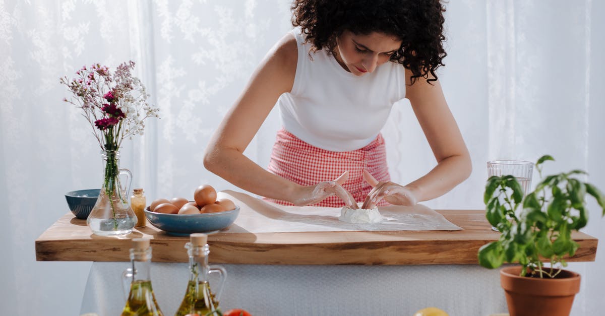 breading/crumbing: mixing the eggs and flour? - Young Woman Mixing Pasta Ingredients on Kitchen Table