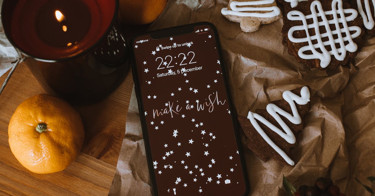 Breaking down fruit with sugar and water for cookies - Smartphone Near Lighted Candle and Mandarin Fruit on Wooden Surface