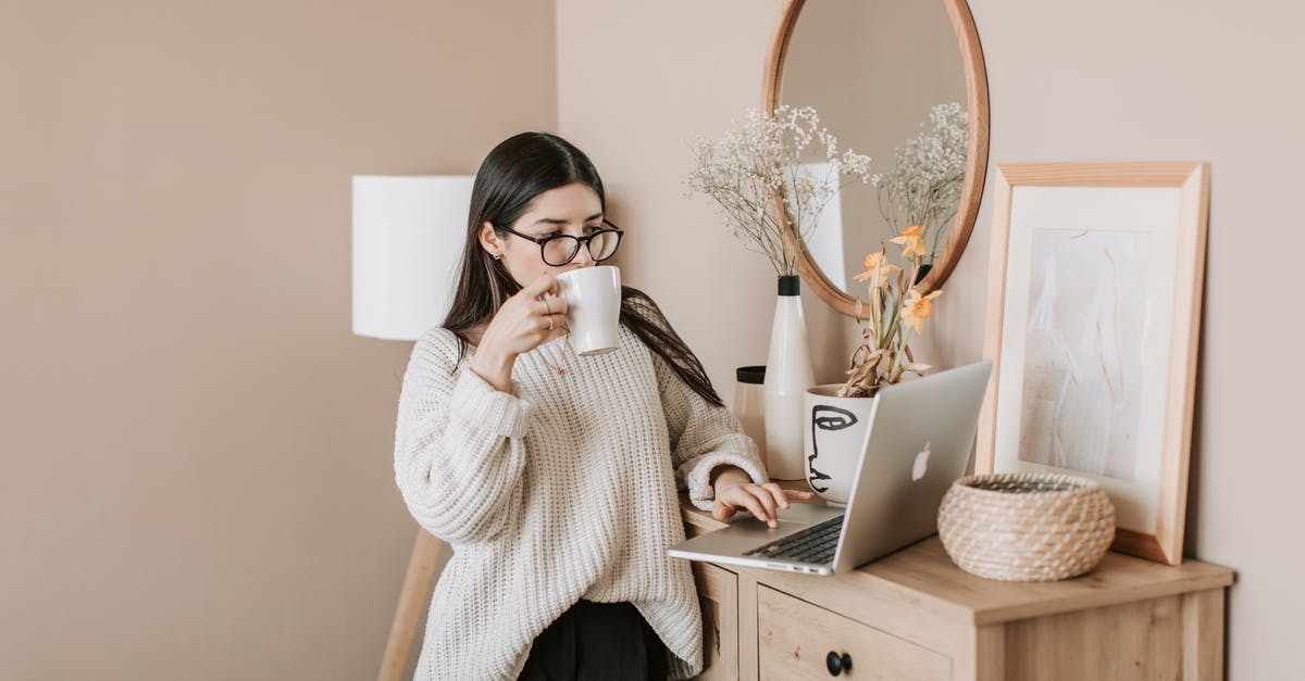 Brewing coffee concentrate using both hot and cold methods - Freezing concentrate - Busy female using laptop and drinking hot beverage at home