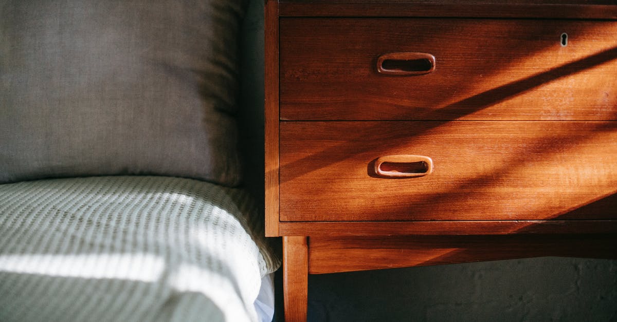 Brine added made sauerkraut too salty - Interior of contemporary cozy bedroom including brown wooden night stand near bed covered with blanket and soft pillow in sun rays