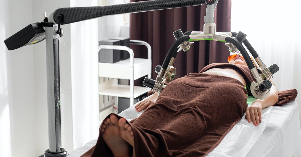 brined turkey and fat - Unrecognizable female under laser weight loss machine on medical table