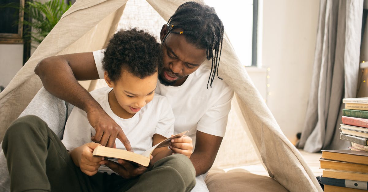 Brisket: separating the flat from the point prior to smoking - Focused African American dad sitting and reading book with positive sun un living room in daytime