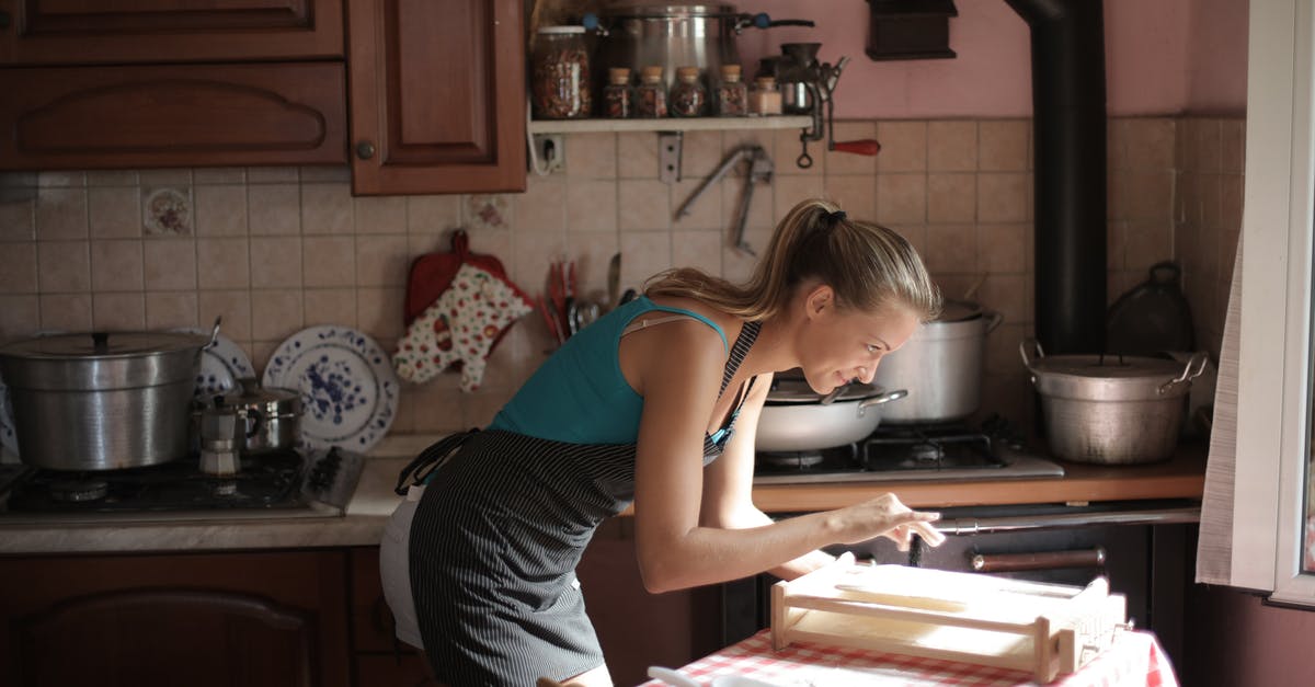 Broiler vs. second baking steel? - Woman in Blue Tank Top Standing Near Kitchen Counter