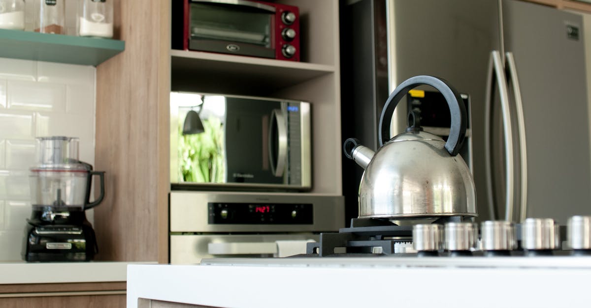 Brown spots on new stainless steel pot - Metal kettle on stove in modern kitchen